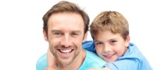 Smiling man giving his son a piggyback ride