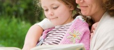 Mother and daughter reading outdoors