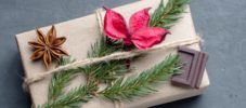 Christmas gift box in paper with winter spices on a gray concrete background Copy space