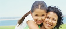 portrait of a daughter riding piggyback on her mother