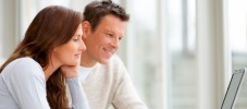 Couple using a laptop and smiling