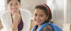 Mother looking at daughter wearing backpack