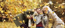 Three generations of women playing in autumn leaves