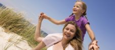 Germany, Baltic sea, Mother carrying daughter (6-7) on shoulders, portrait