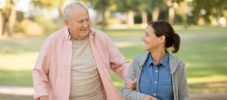 senior woman and caregiver go walking outdoors