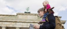 Father sightseeing whilst giving baby daughter shoulder ride, Brandenburg Gate, Berlin, Germany