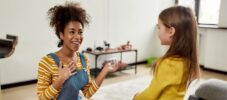 Glad to meet you. African american woman baby sitter get acquainted with caucasian cute little girl. They are smiling and talking