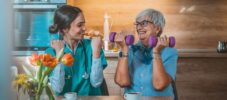 Nurse helping senior woman in lifting dumbbells