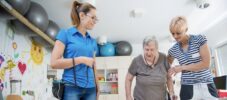 Caregivers Helping Senior Woman to Walk With a Dog In Retirement Home