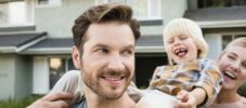 Happy parents with son in front of their home